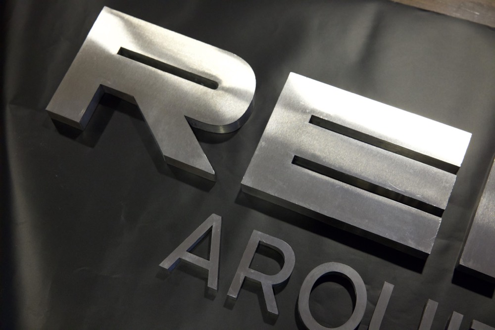 Detalle de letras en acero inoxidable de Remus Arquitectura