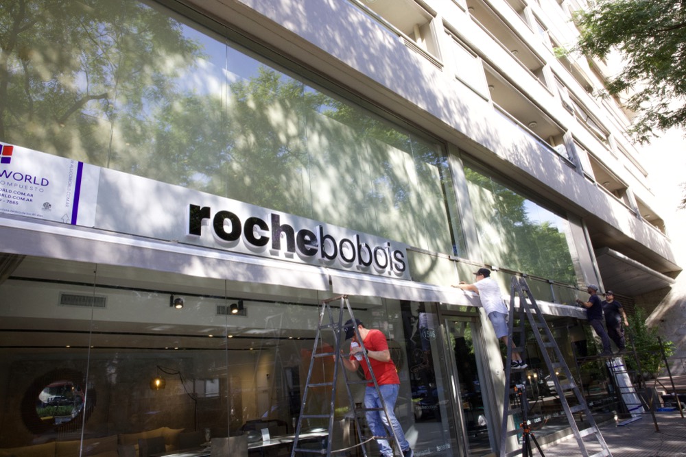 Equipo de HL Publicidad colocando el frente de Roche Bobois