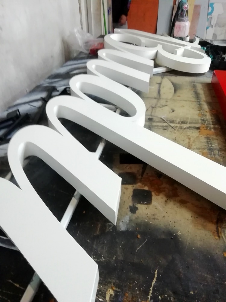 Letras corpóreas blancas en el taller antes de la entrega
